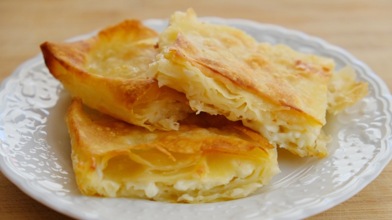 Isečena pita sa sirom poslužena na tanjiru na stolu